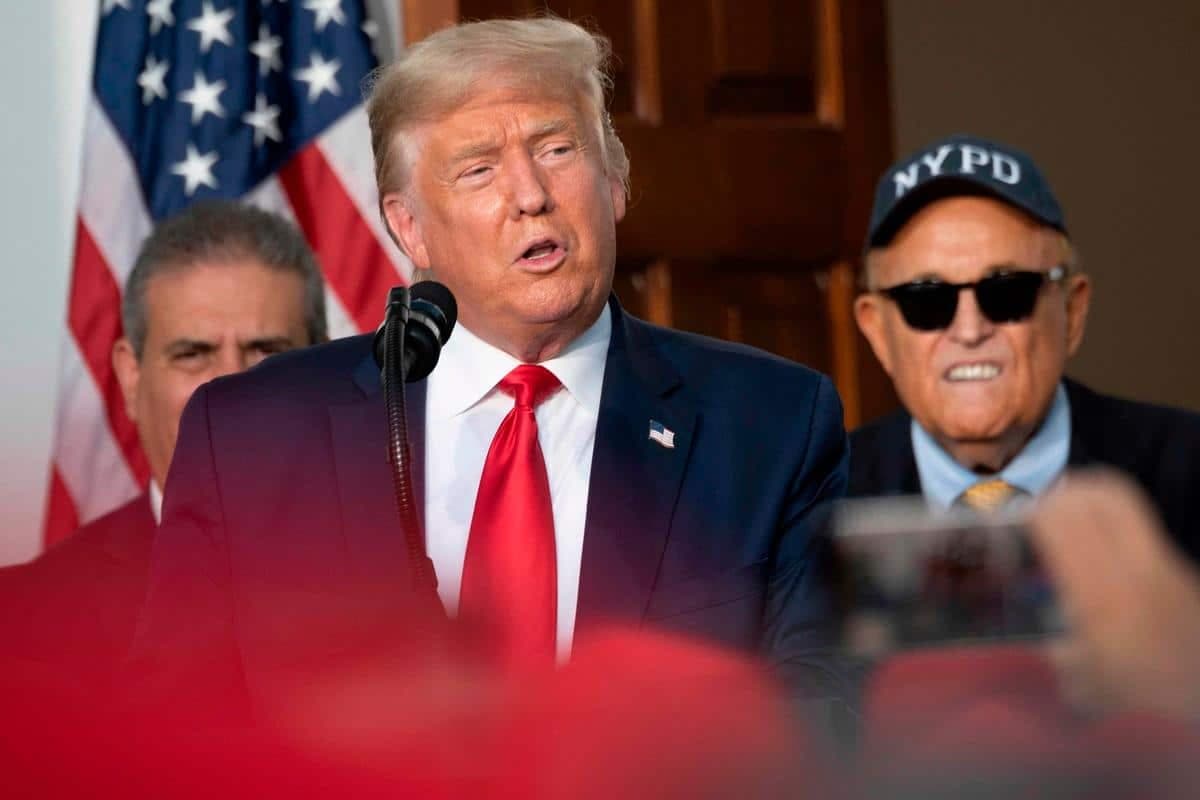 Rudy Giuliani (à droite) écoute Donald Trump parler, le 14 août, 2020. (Photo by JIM WATSON / AFP)
