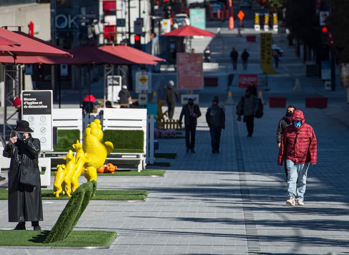 Une personne portant un masque marche sur la rue Sainte-Catherine Ouest dans le cadre de la deuxième vague de la pandémie de COVID-19, à Montréal, lundi le 12 octobre 2020. JOEL LEMAY/AGENCE QMI