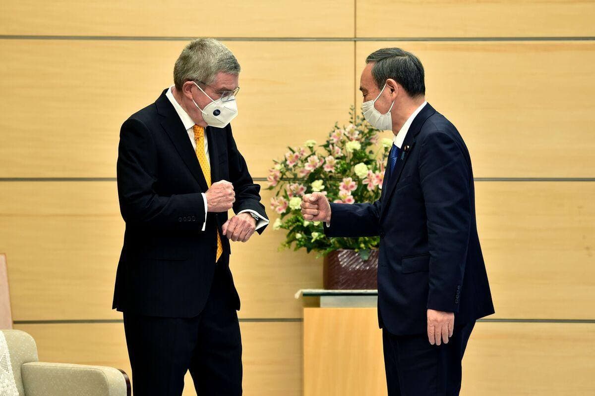 Le président du Comité International Olympique (CIO) Thomas Bach (à gauche) accueille le premier ministre du Japon Yoshihide Suga (à droite) le 16 novembre 2020.