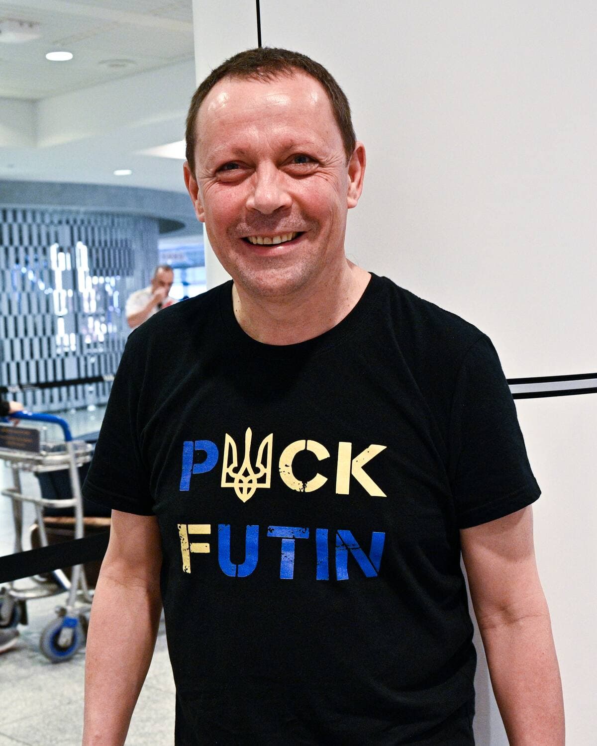 Evgueni Fadeitchev attend une famille de trois Ukrainiennes et arbore fièrement un chandail au message peu subtil : Puck Futin.