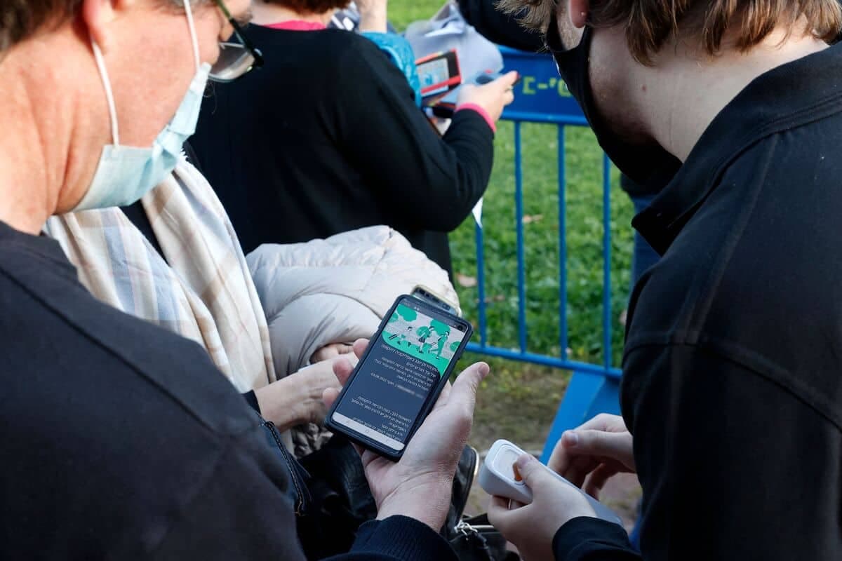 Un homme israélien montre sa passe verte, un passeport vaccinal attestant qu'il est immunisé contre le coronavirus, avant d'entrer dans un concert organisé pour les personnes âgées vaccinées à Tel-Aviv le 24 février. Les personnes qui détiennent cette carte ont des accès privilégiés à certains services et activités.