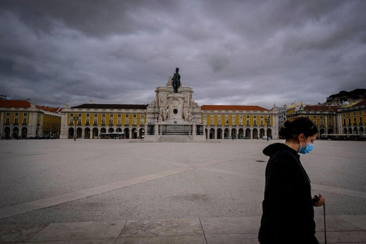 Une femme marche le 11 mars 2021 à travers la place du Commerce à Lisbonne
