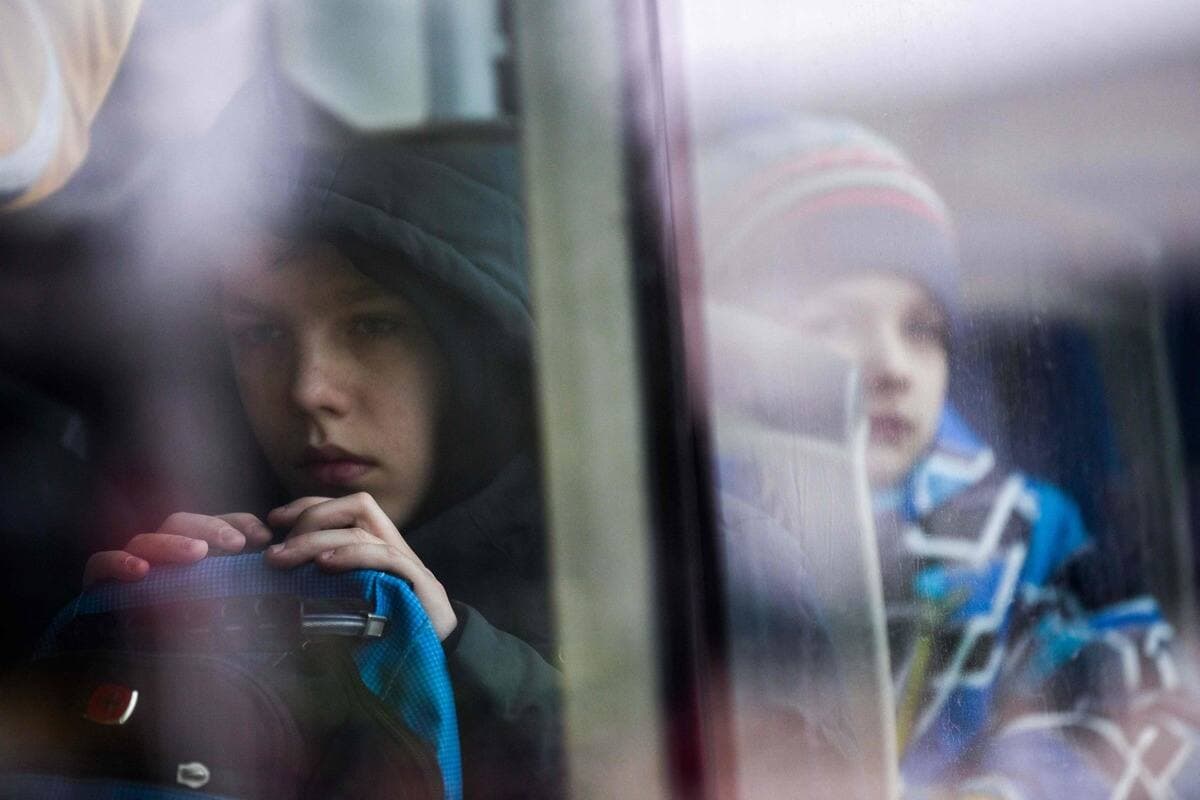Deux enfants ukrainiens attendent dans un autobus après avoir traversé la frontière avec la Roumanie.