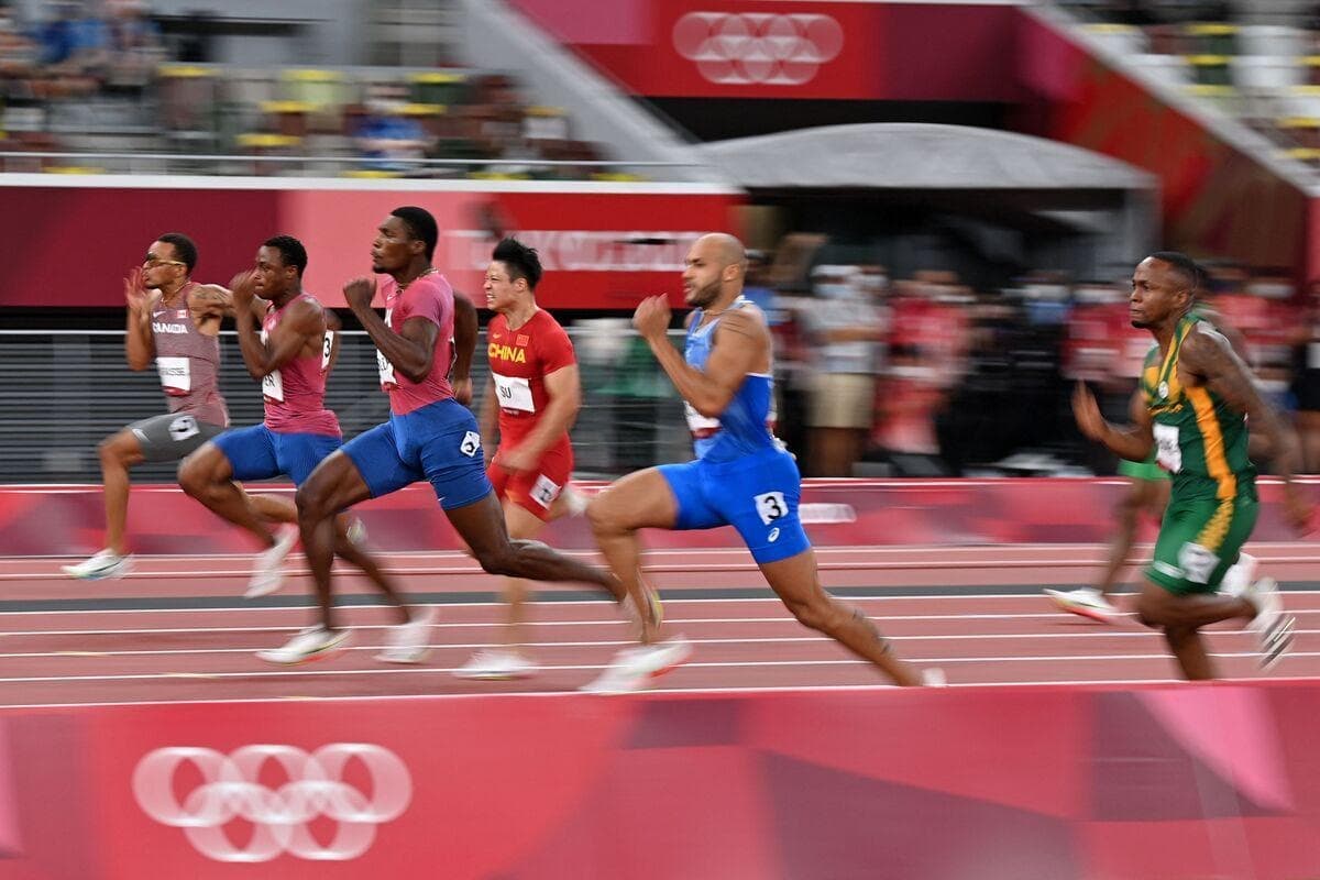 Andre De Grasse (haut de la photo) a effectué une remontée dans le 9,[object Object], corridor pour franchir le fil d’arrivée au 3,[object Object], rang. Après le 100 m, il s’est drapé dans l’unifolié canadien.