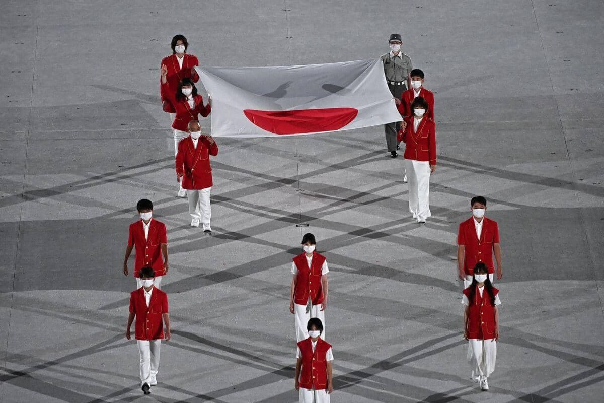 Des athlètes amènent le drapeau du Japon lors de la cérémonie.