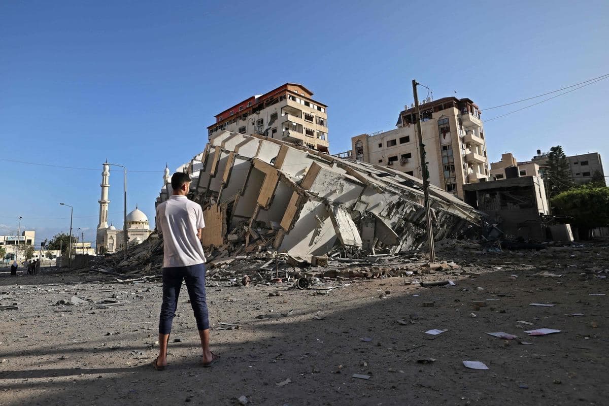Sur cette image : un homme regarde un bâtiment de Gaza détruit lors d’un raid aérien.