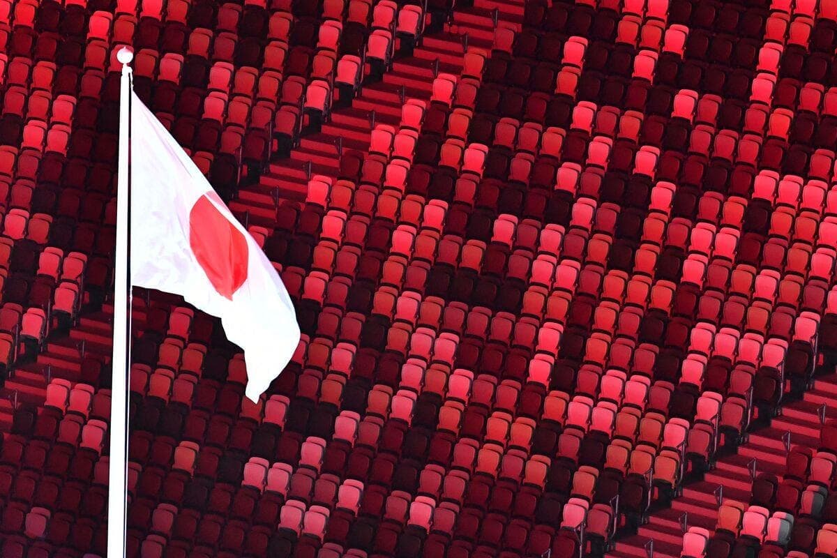 Le drapeau du Japon hissé dans le Stade olympique de Tokyo pratiquement vide.