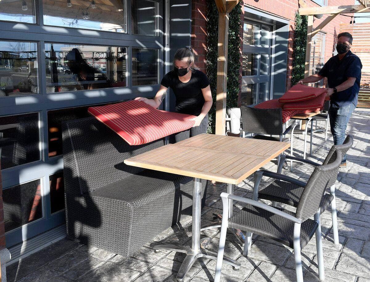 Préparation de la terrace de la Cage aux Sports Lebourneuf pour son ouverture de vendredi a Quebec, jeudi le 27 mai 2021. Christian Guenette, directeur et une employée place des coussins STEVENS LEBLANC/JOURNAL DE QUEBEC/AGENCE QMI)