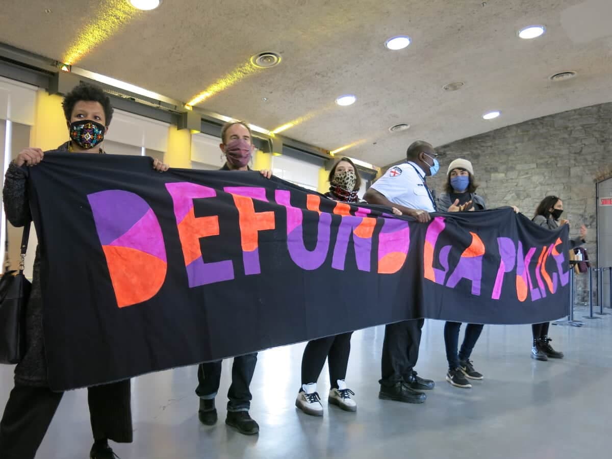 Des militants réclament le définancement du Service de police de la Ville de Montréal ont fait irruption au marché Bonsecours, dans la pièce où la mairesse de Montréal, Valérie Plante, devait présenter son budget 2021; de telle sorte que la présentation a été déplacée dans une salle voisine, jeudi le 12 novembre 2020.