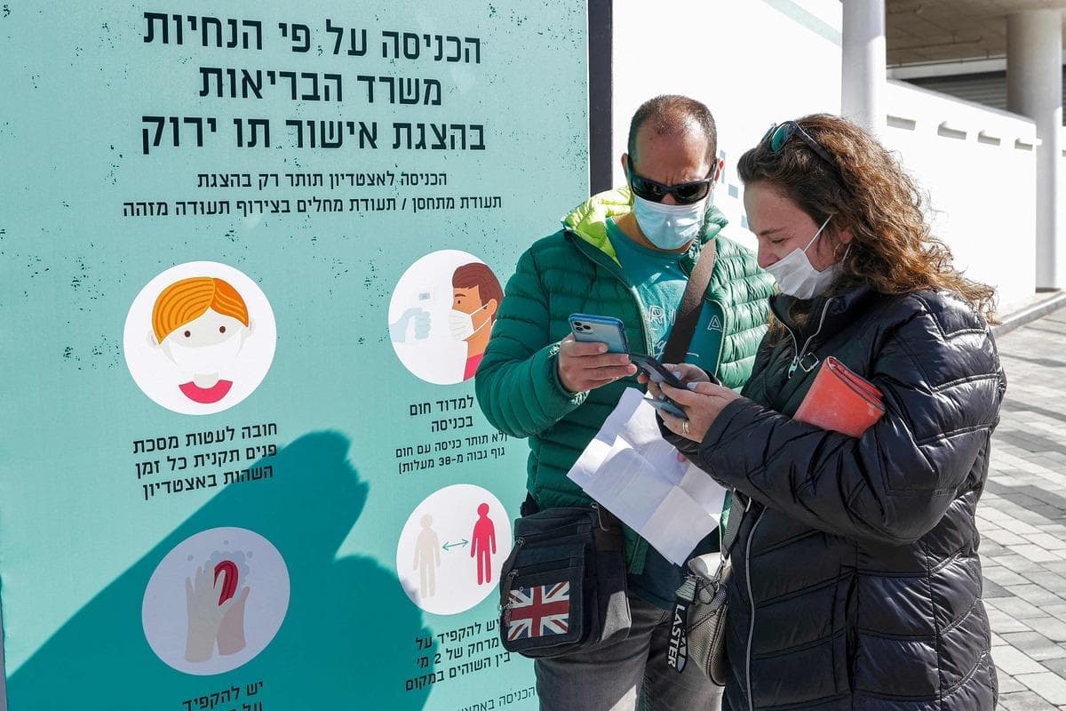 Des Israéliens se préparent à montrer leur «passeport vert» avant d'entrer dans un stade de Tel Aviv.