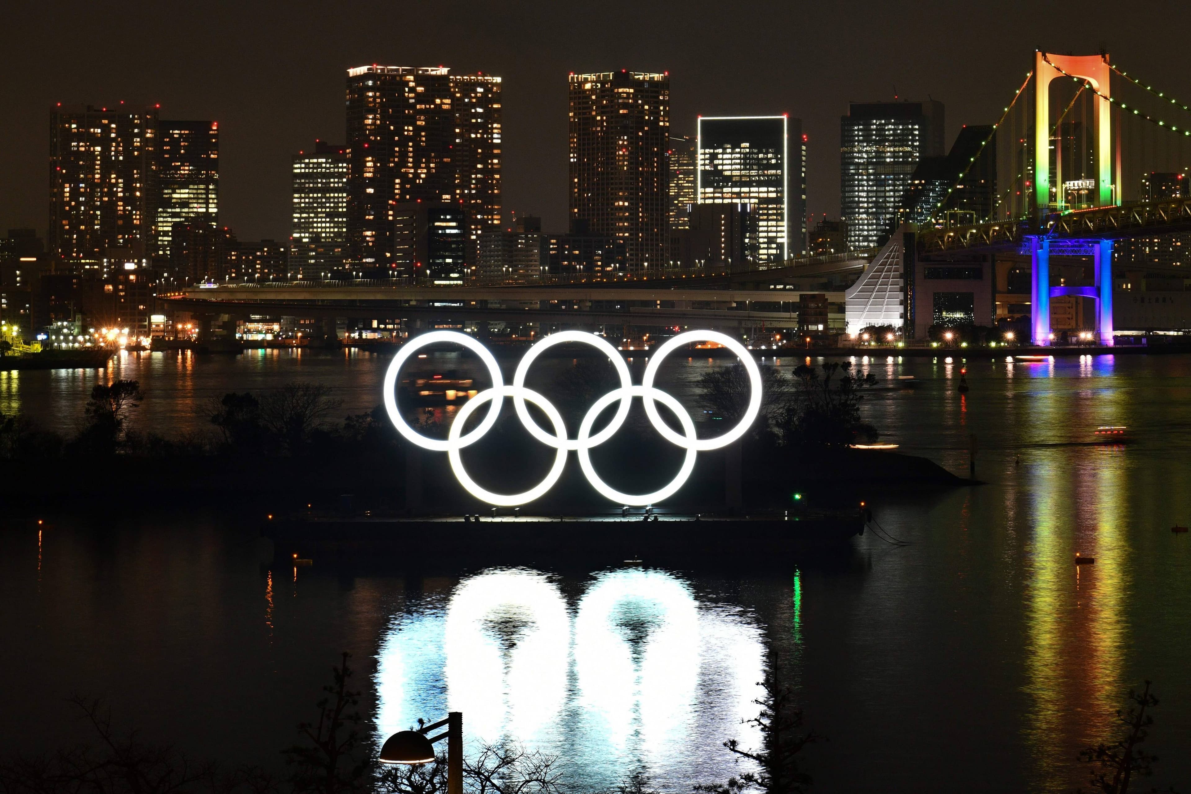 Les anneaux olympiques brillent près du Odaiba Marine Park le 24 janvier 2020 durant une cérémonie marquant les six mois avant l'ouverture des Jeux olympiques (JO) de Tokyo. Les JO ont été remis à l'été 2021.