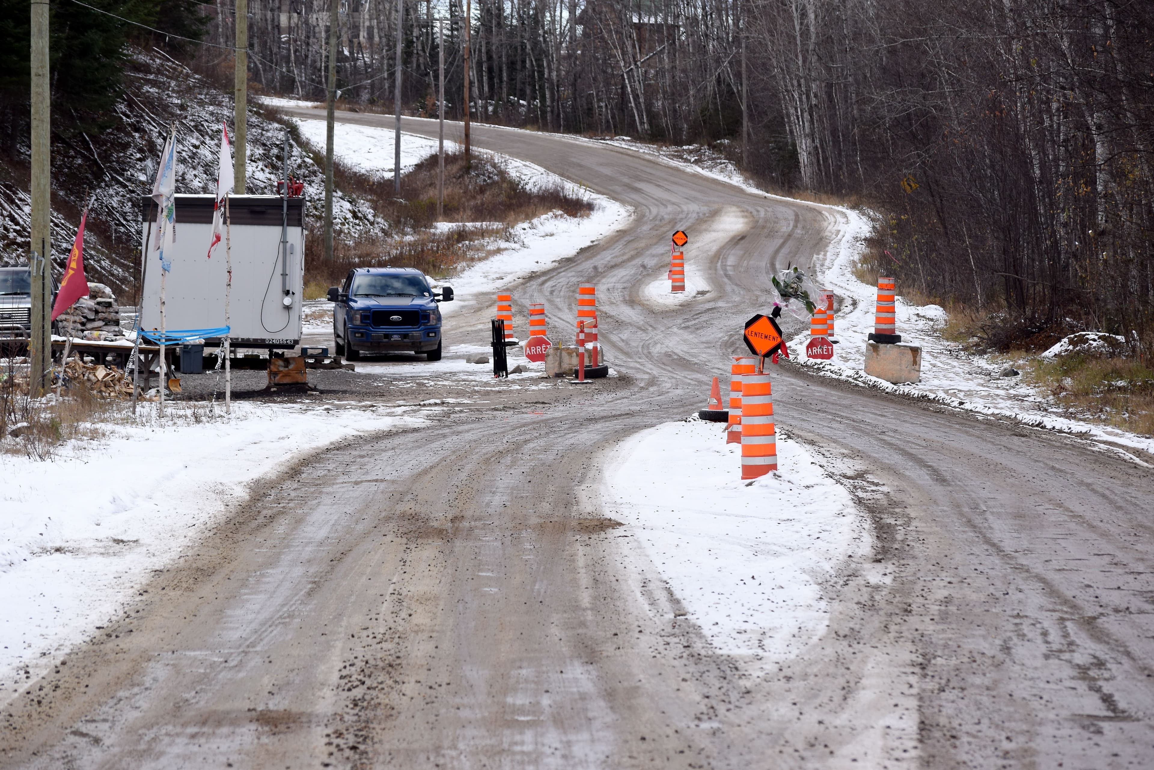 Sur cette photo, on peut voir le mauvais état de la chaussée et les panneaux de signalisation à l’entrée du village.