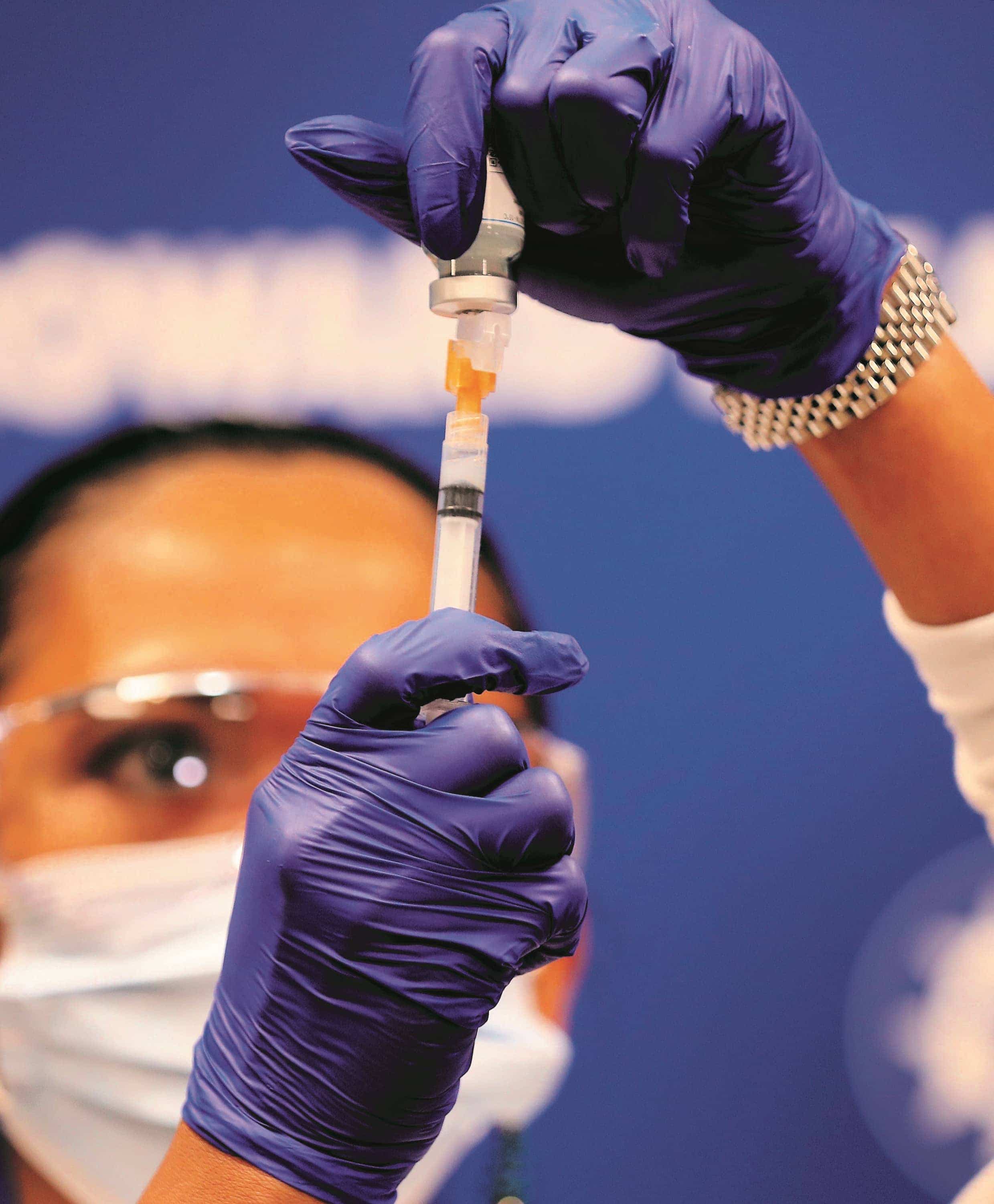 Une infirmière s’apprête à injecter le vaccin conçu par Pfizer.