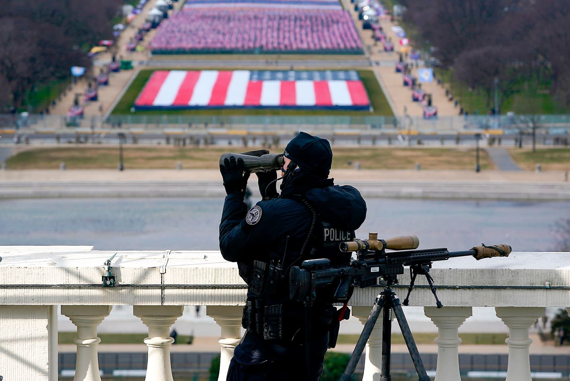 Un membre des forces de l’ordre surveillait mercredi avec attention tout mouvement depuis un balcon face au National Mall à Washington.