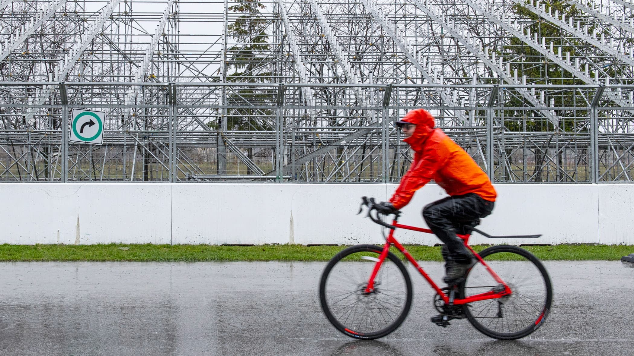 Un cycliste pédalait sous la pluie, jeudi, devant les estrades vides du Grand Prix de F1 du Canada, au circuit Gilles-Villeneuve.