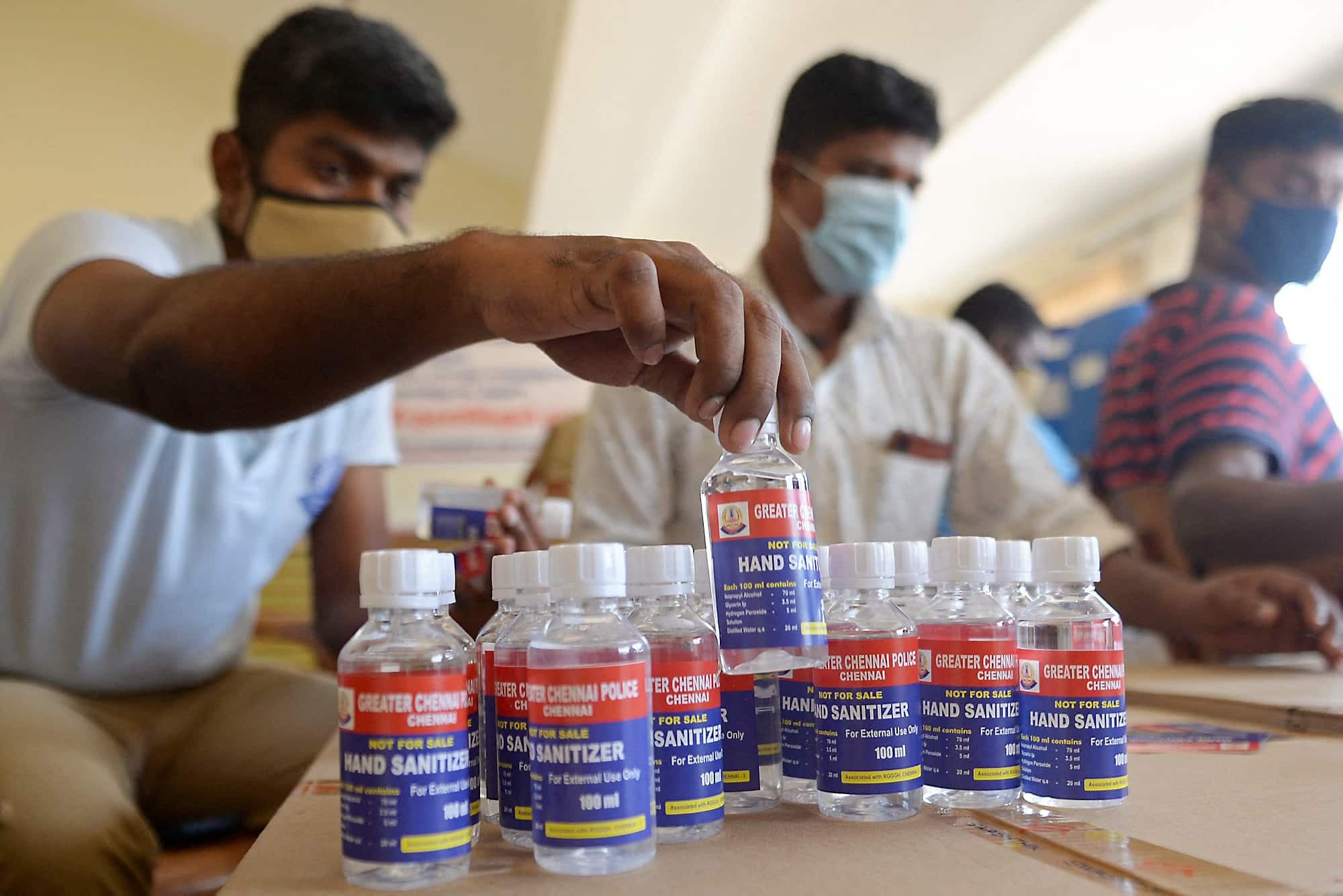 Des policiers indiens préparent des flacons de désinfectant pour les mains à l’intention de leurs collègues.
