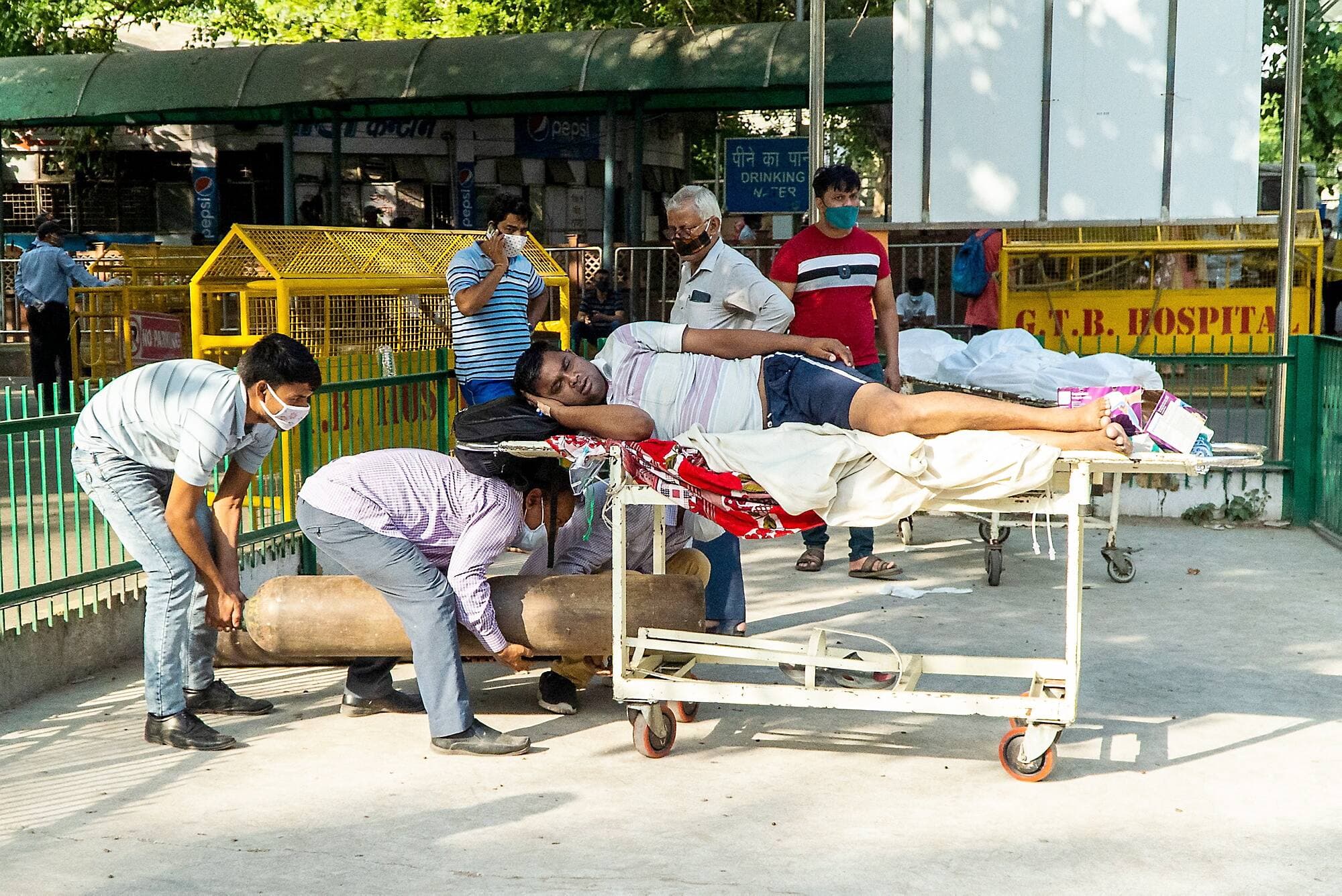 Un patient atteint de la COVID-19 est allongé sur une civière à l’extérieur alors qu’il attend d’être admis à l’hôpital, à Delhi.