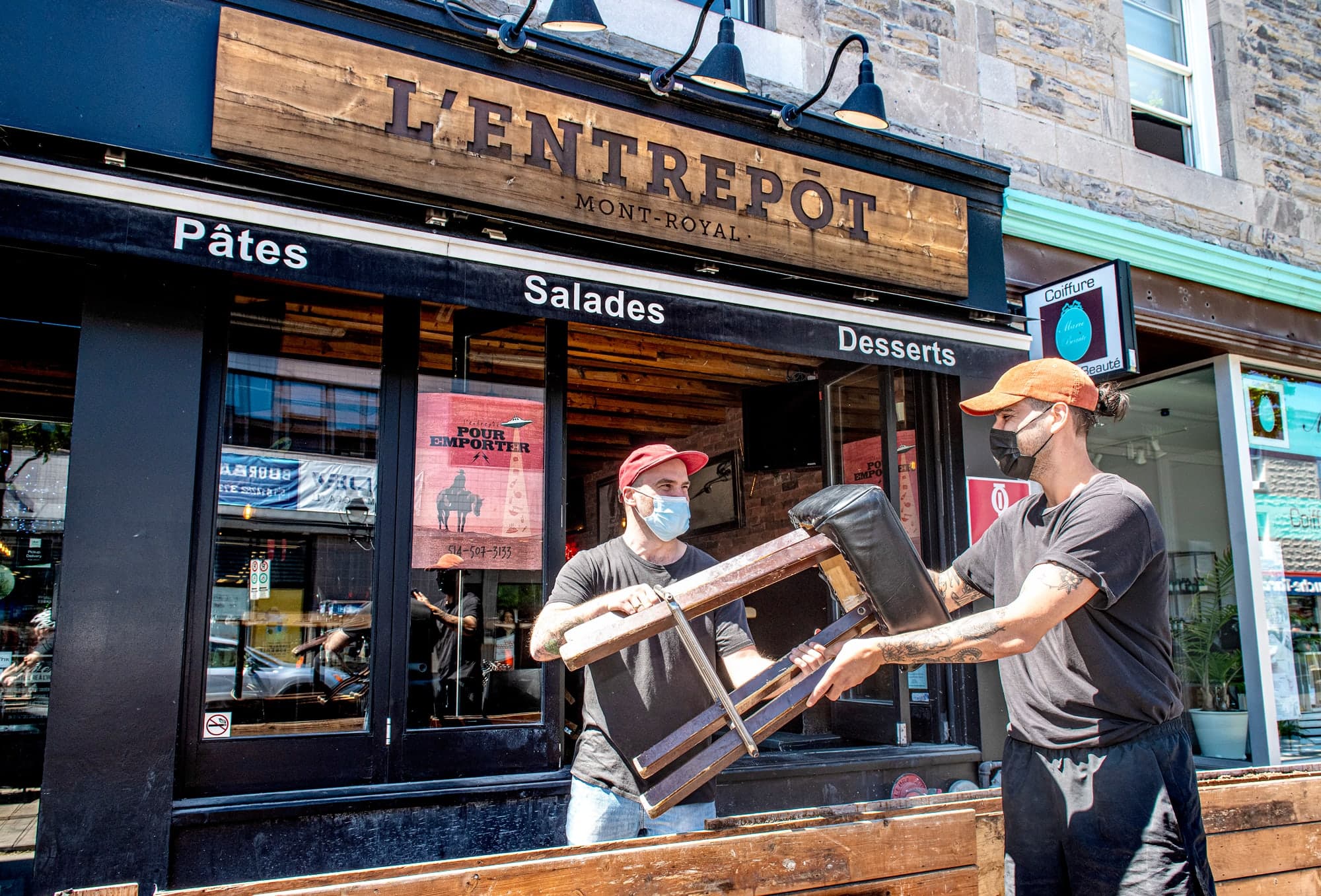 Mac Charette (à gauche) et Nicolas Brassard, du restaurant L’Entrepôt de l’avenue Mont-Royal, à Montréal, montent leur terrasse en vue de l’ouverture, vendredi.