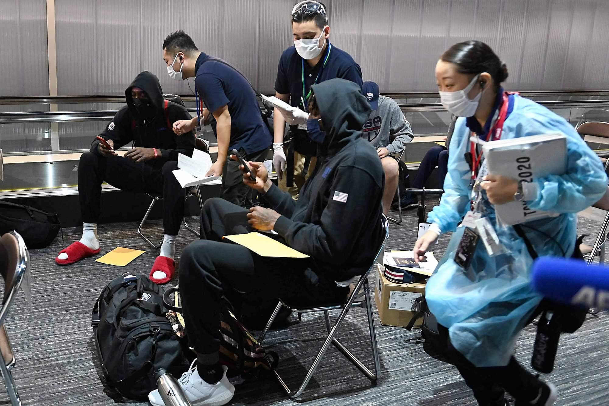 De nombreux employés de l’aéroport et des Jeux font tout pour aider les visiteurs, comme ces trois Japonais avec des membres de l’équipe de basketball des États-Unis.