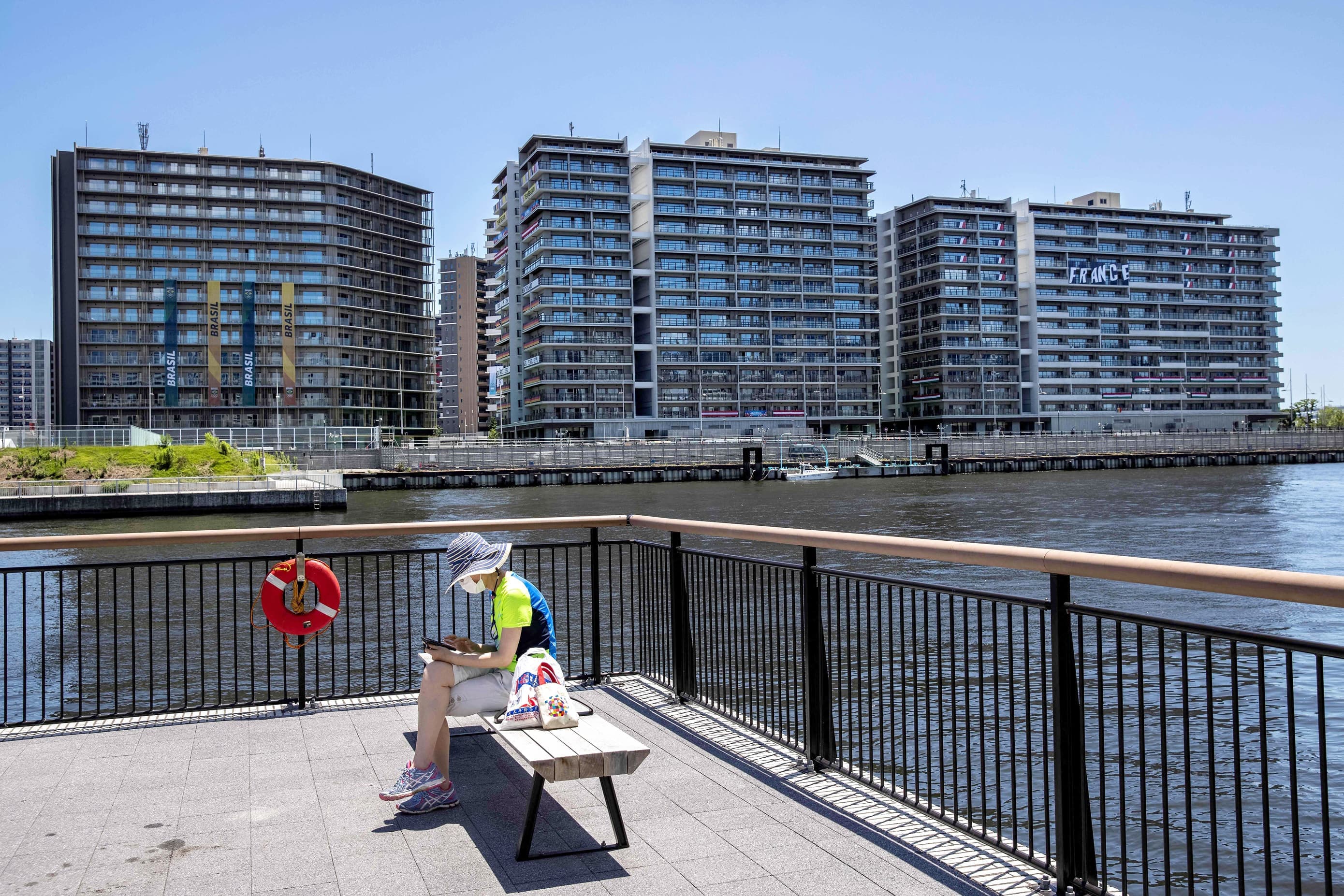 Quelques kilomètres plus loin, une athlète se prélassait sous le soleil face aux immeubles du village olympique.