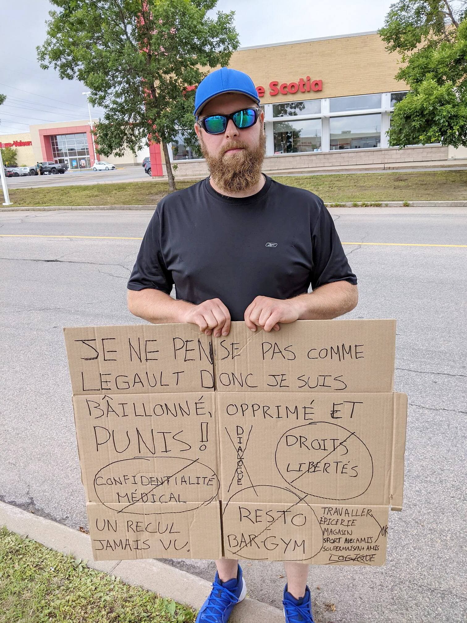 Un opposant à la nouvelle mesure affiche son désaccord à quelques mètres de l’entrée du restaurant.