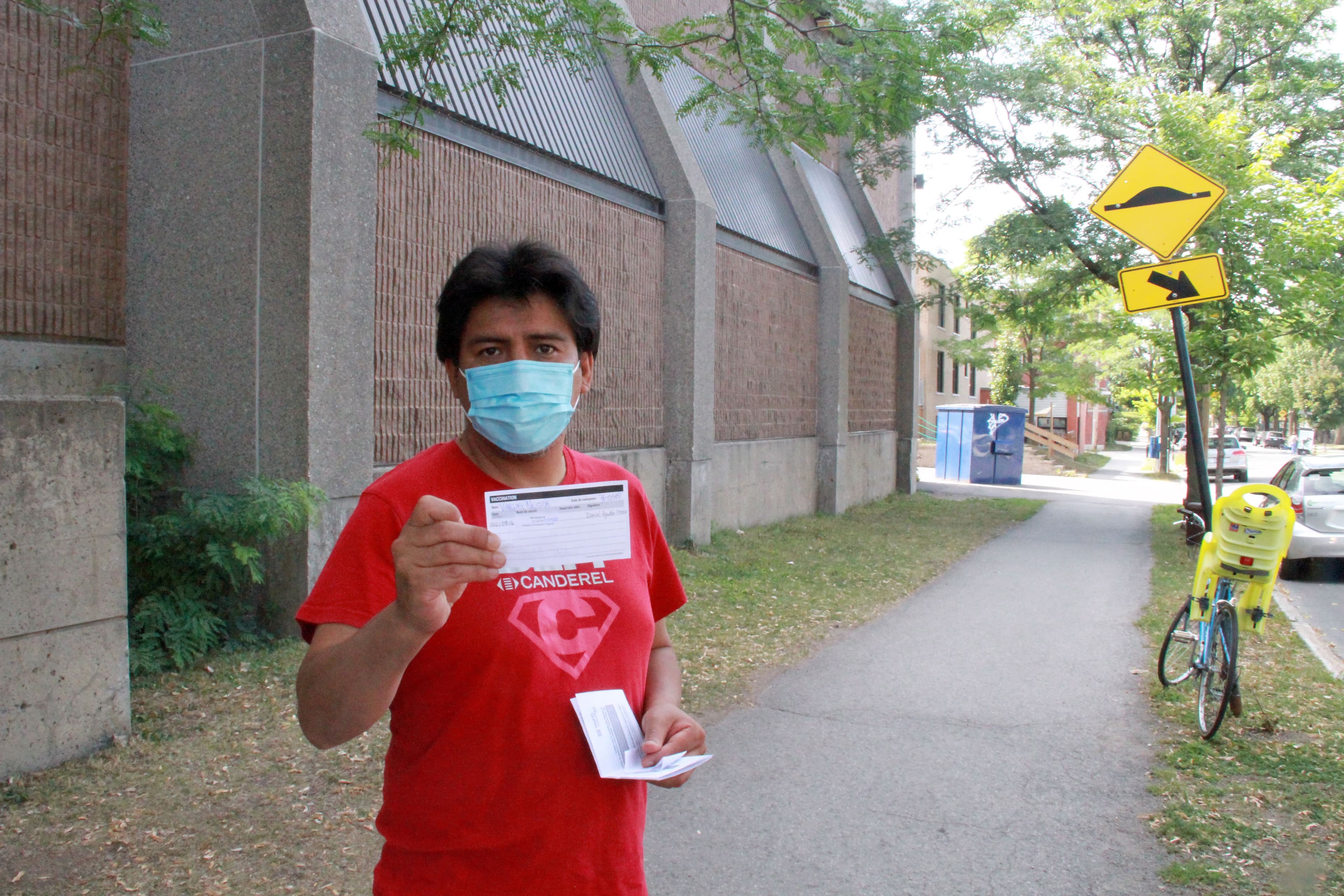 Nestor Vargas, 45 ans, montre fièrement sa preuve de vaccination. Il a finalement surmonté son hésitation à recevoir l’injection pour le bien de sa famille.