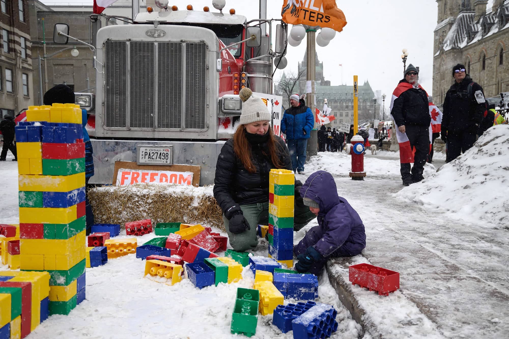 Un tout-petit assemblait des blocs dans une aire de jeux prévue pour les jeunes manifestants, tout près d’une scène de concert.