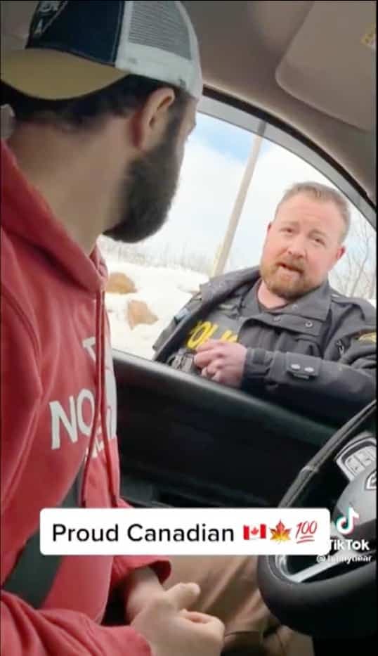 Un policier ontarien encourage des gens à participer au siège d’Ottawa.