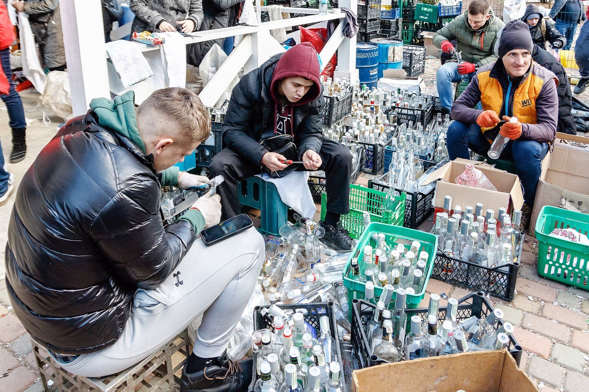 Des jeunes hommes s’affairent à produire une grande quantité de cocktails Molotov dans un parc de Oujgorod, une ville du sud-ouest de l’Ukraine.