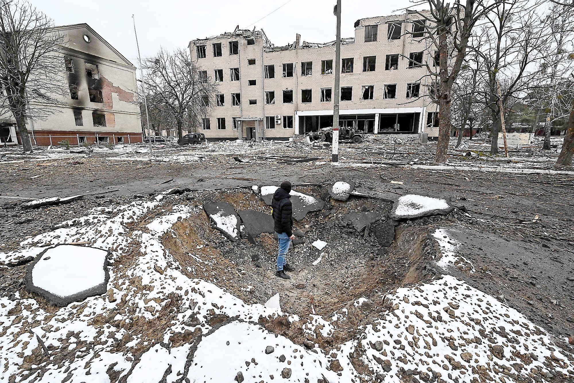 Un homme se tient dans un cratère qui a été causé par une bombe russe, mardi, à Brovary. La bombe a touché une installation militaire.