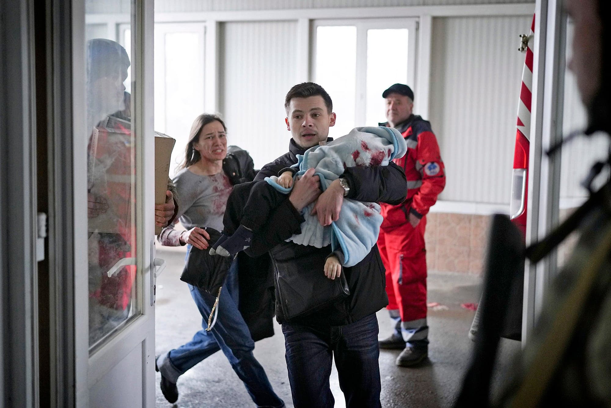 Cette photo montre un père portant son bébé de 18 mois blessé accourir dans un hôpital de Mariupol pour qu’il soit soigné. La mère les suit quelques pas derrière. Le petit Kirill ne survivra malheureusement pas à ses blessures.