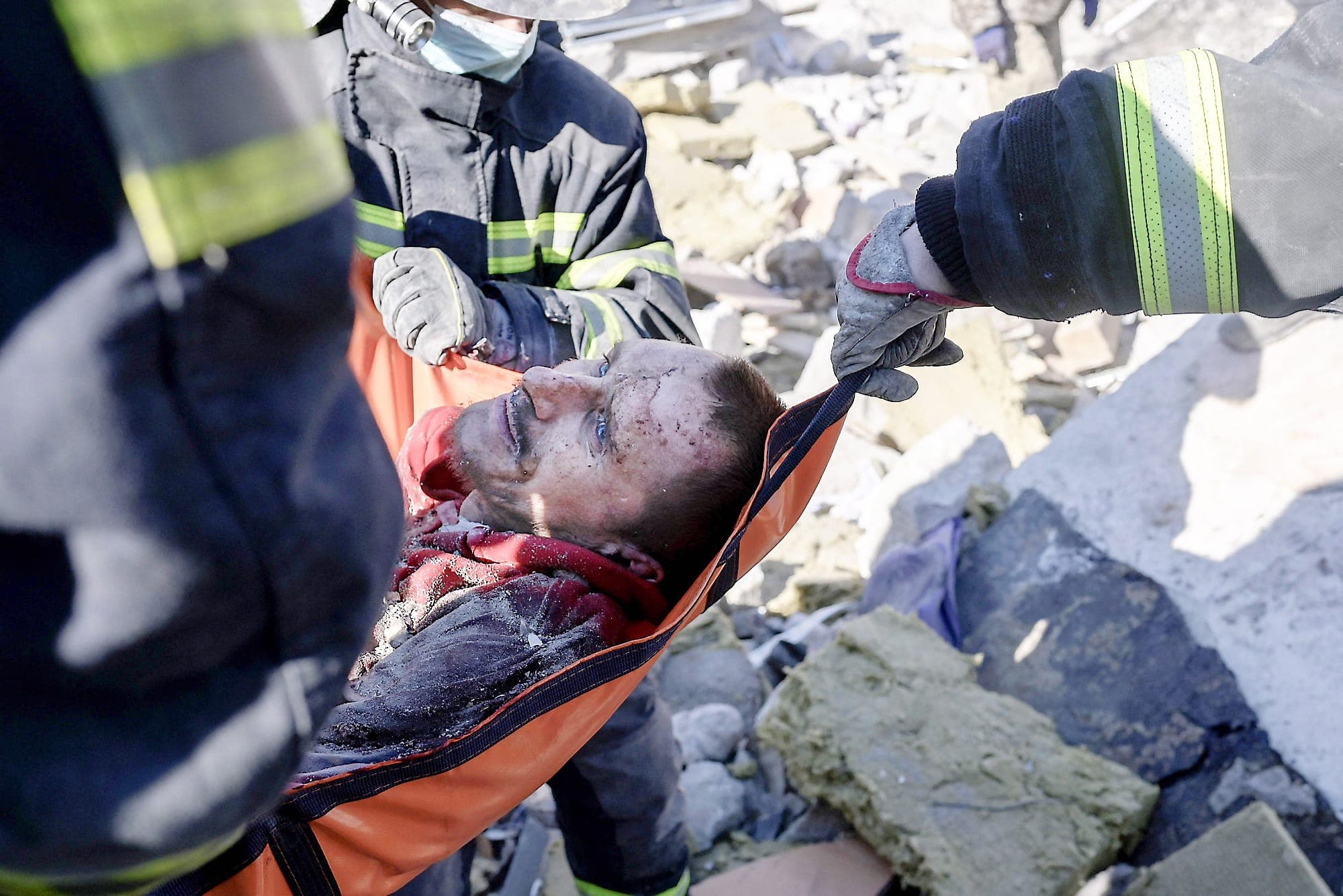 Des secouristes transportent un soldat sauvé après 30 heures sous les débris.