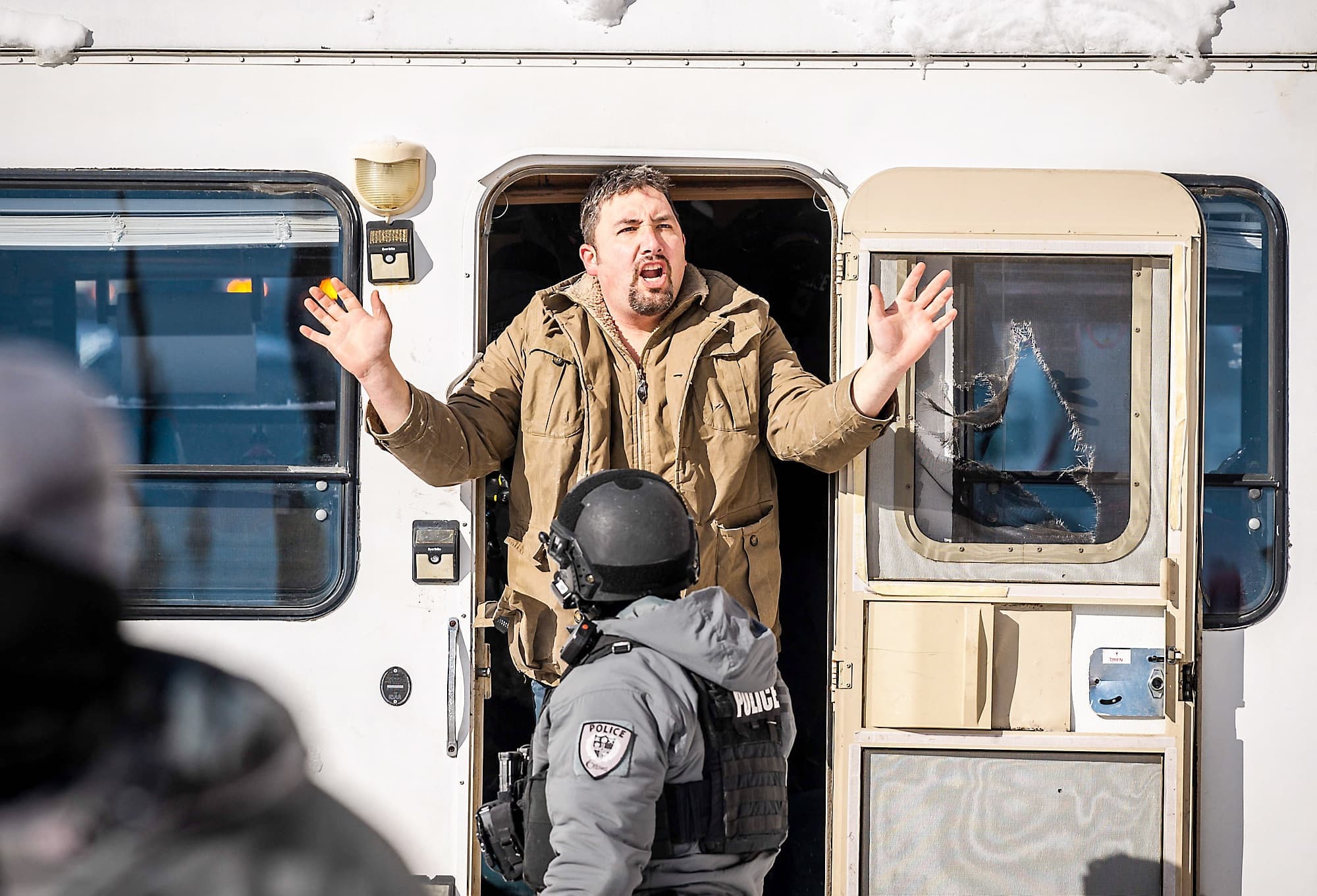 Ce manifestant s’est rendu après que les policiers eurent brisé plusieurs fenêtres de son véhicule récréatif.