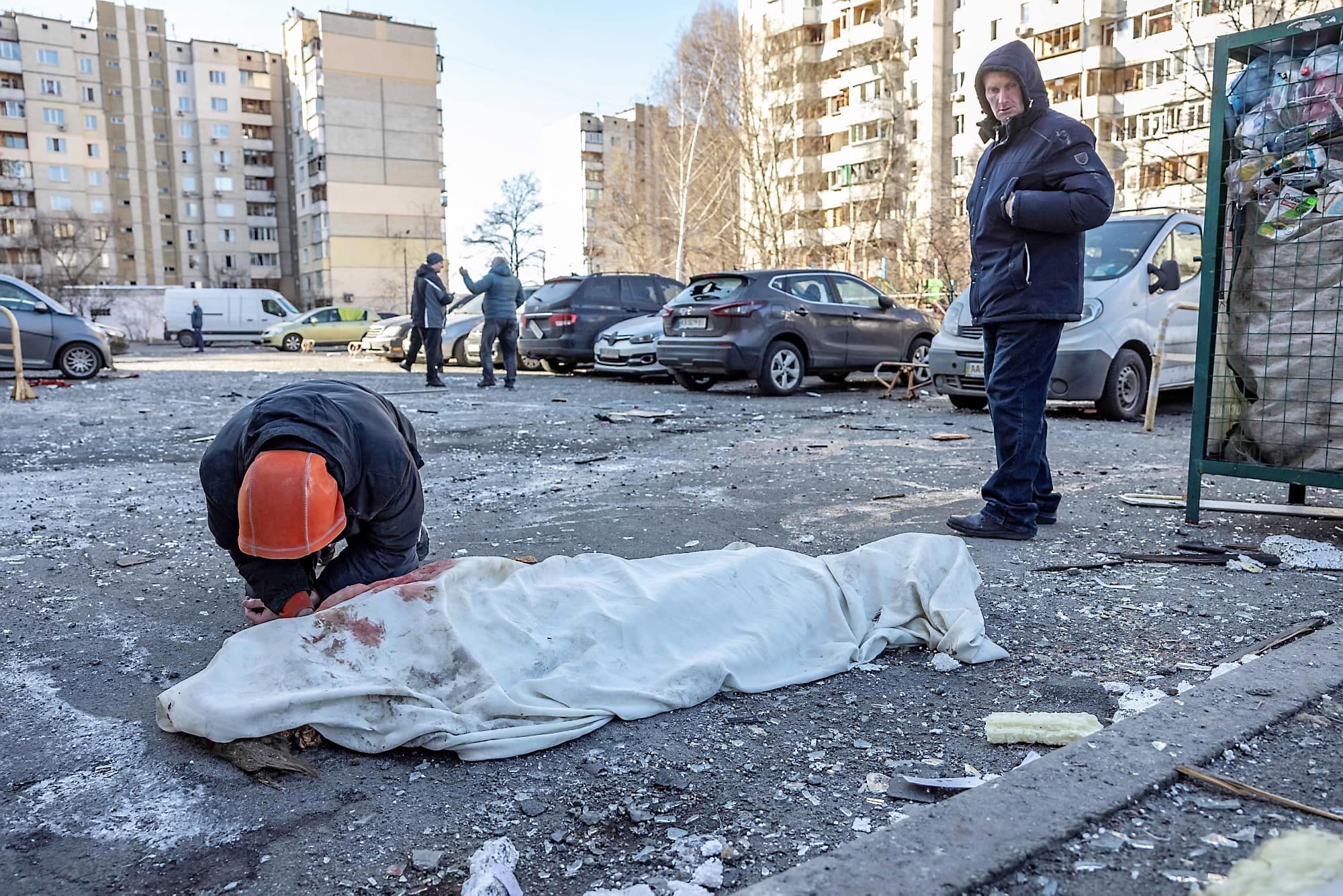 Un homme agenouillé tient la main inerte d’un proche tué par des débris après qu’un bâtiment résidentiel a été touché par un missile, abattu au-dessus de Kyïv jeudi. Après la scène déchirante, l’homme, silencieux, a quitté les lieux en chancelant.