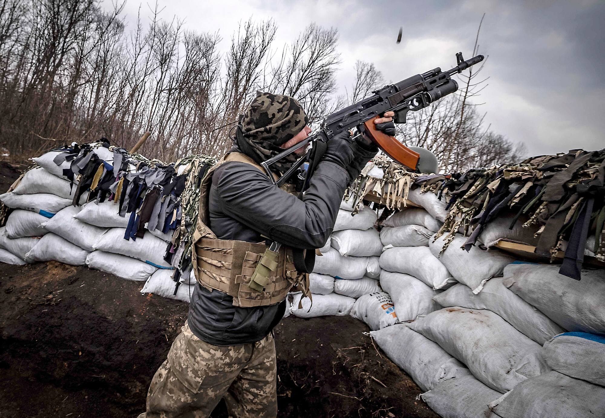 Un militaire ukrainien tire avec un fusil d’assaut depuis la tranchée d’une ligne de front à l’est de Kharkiv.