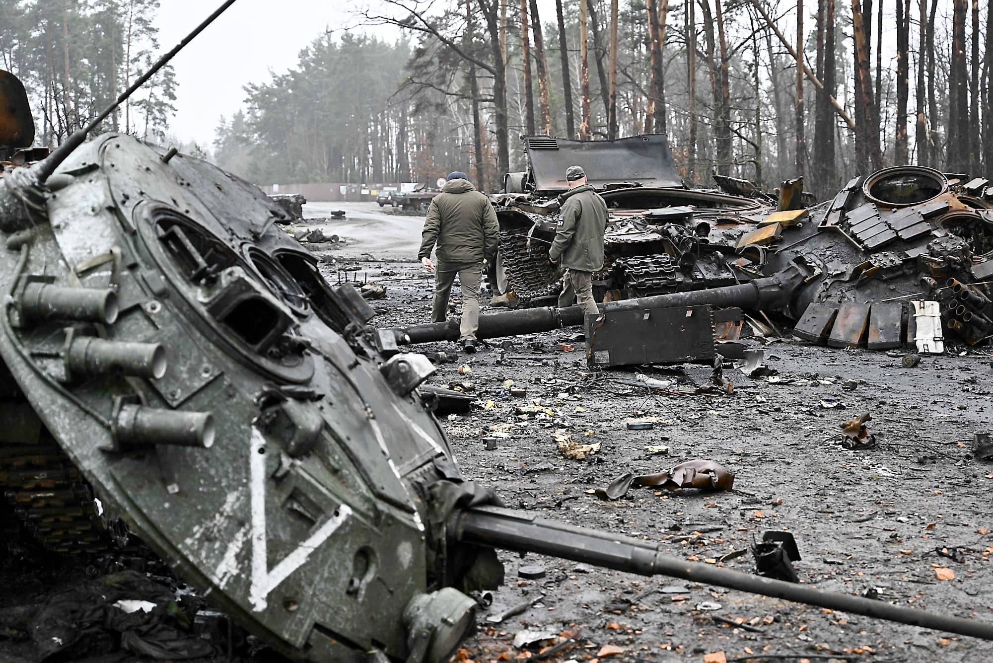 Des militaires ukrainiens marchent à travers des chars russes pulvérisés dans le village de Dmytrivka, dans la banlieue ouest de Kyïv.