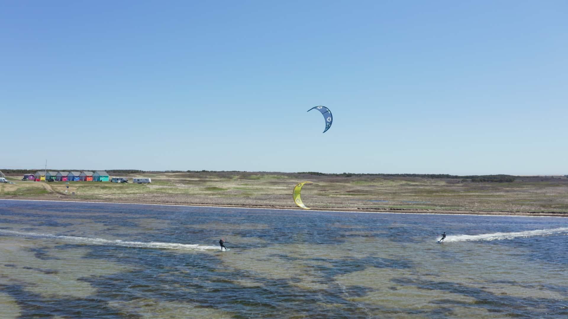Les chalets de la baie, au fond à gauche, sont un peu le bureau des deux couples d'entrepreneurs, qui enseignent ou pratiquent le kite dans le lagon en face.