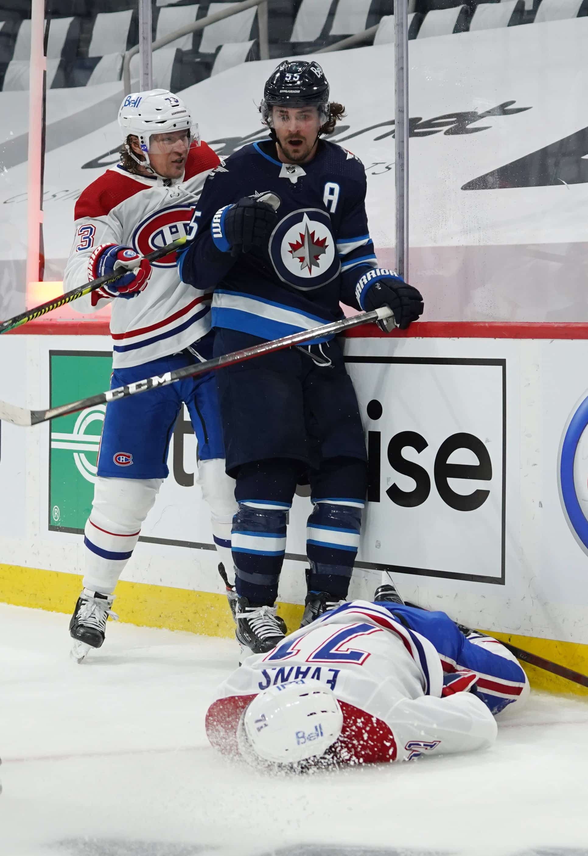 Mark Scheifele semble constater la gravité de sa mise en échec à l’endroit de Jake Evans, qui gît presque inconscient sur la patinoire. Tyler Toffoli est venu à la rescousse de son jeune coéquipier, ce qui a donné lieu à une foire d’empoignade derrière le filet des Jets.